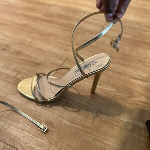 Gold strappy heeled sandal for women. About a 3 inch heel